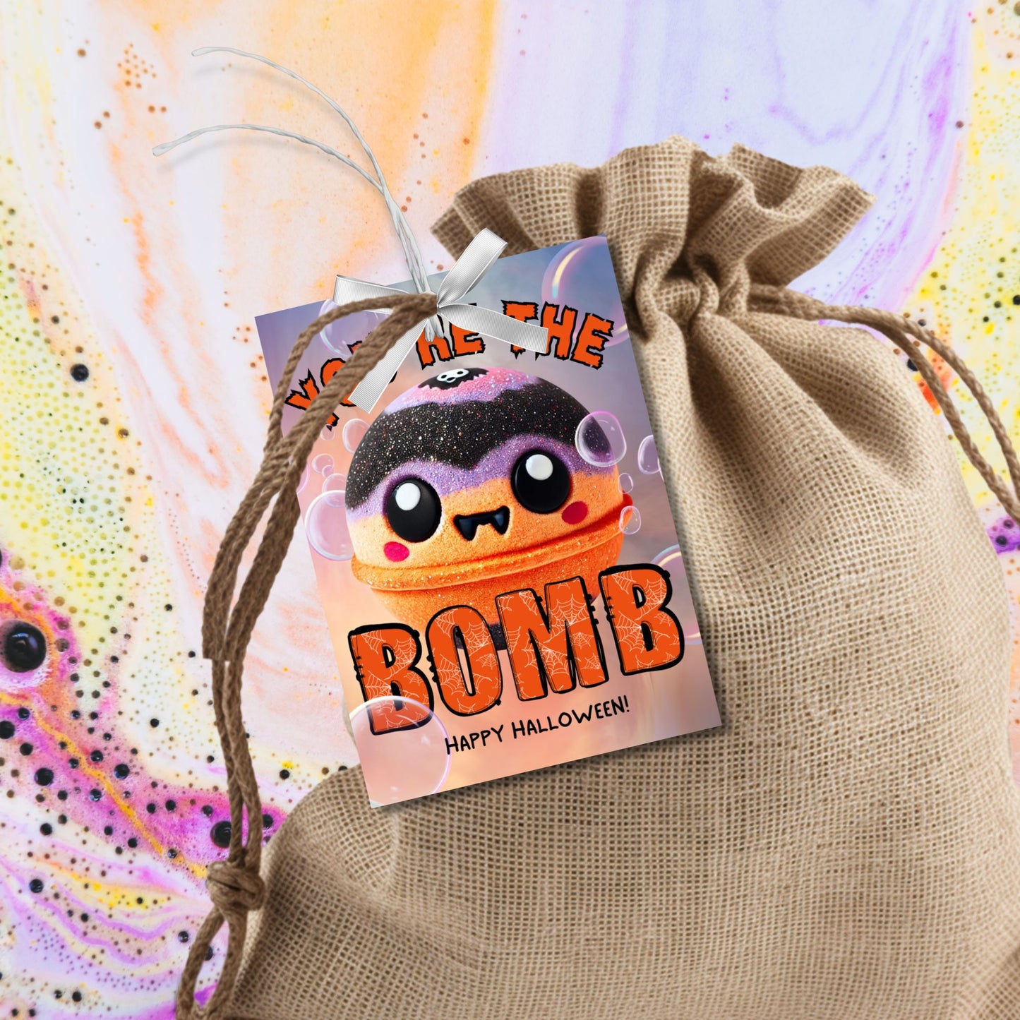 Halloween-themed printable gift tags with the message "You're the Bomb" featuring a cute and spooky bath bomb character, perfect for bath bomb gifts. Tags are 2.5 x 3.5 inches, laid out 8 per sheet on a standard 8.5 x 11-inch page. Includes a printable PDF and a PDF with a link to an editable Canva template.