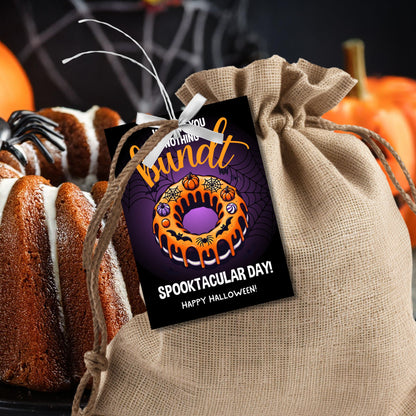 Halloween gift tag featuring a bundt cake decorated with pumpkins and spiderwebs, with the message 'Wishing You Nothing Bundt a Spooktacular Day!'