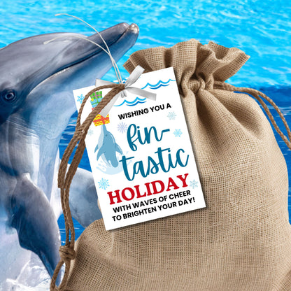 Dolphin-themed holiday gift tags featuring a cheerful dolphin balancing Christmas presents, with the message 'Wishing you a fin-tastic holiday with waves of cheer to brighten your day!' Perfect for adding a fun and ocean-inspired touch to holiday gifts.