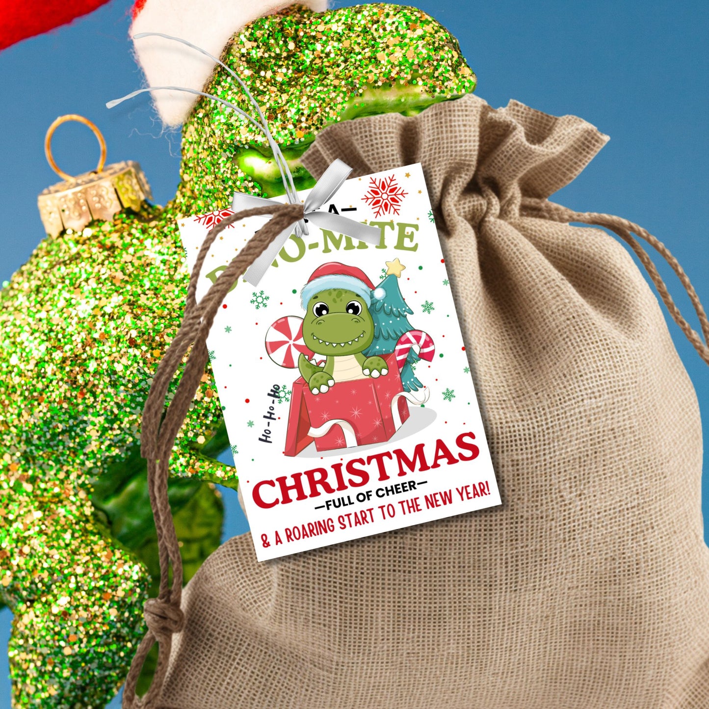 Adorable dinosaur-themed Christmas gift tags featuring a festive green dino in a Santa hat and the message 'Have a Dino-Mite Christmas full of cheer & a roaring start to the New Year!' Perfect for adding a playful touch to holiday gifts.