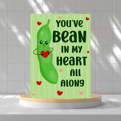 Printable Valentine’s Day Greeting Card featuring the phrase “You’ve Bean in My Heart All Along” with a cute bean design. Designed as a 5x7 PDF on an 8.5 x 11 sheet with two cards per page. A punny and heartfelt Valentine’s card for loved ones.