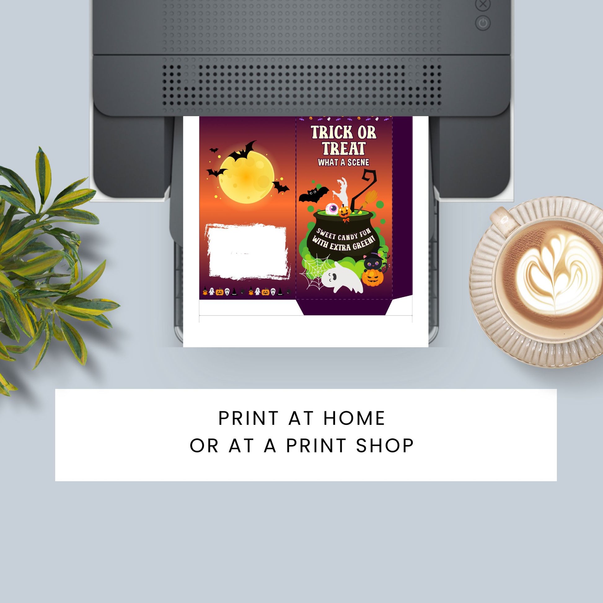 Halloween-themed print design on a printer with a cup of coffee and plant in the background.