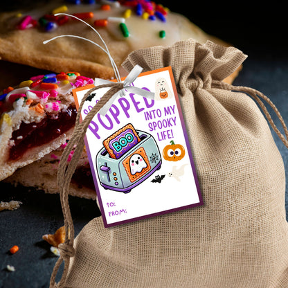 Halloween gift tag featuring a toaster with Pop-Tarts and ghosts with the message 'So Glad You Popped into My Spooky Life!' for Halloween Pop-Tart gifts. Perfect for printable and editable Halloween treat tags.