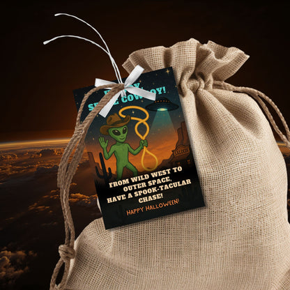 Alien holding a lasso on a Wild West Halloween gift tag with stars and space-themed elements, captioned "Howdy, Space Cowboy!"