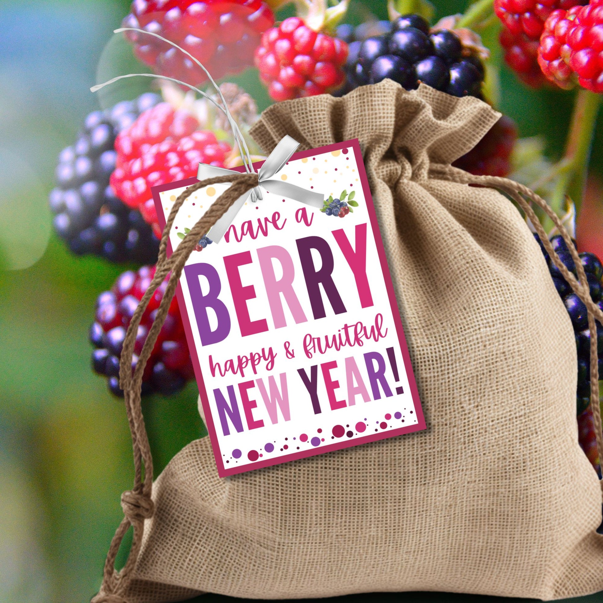 Berry-themed editable New Year gift tags with the message “Have a Berry Happy & Fruitful New Year!” laid out on an 8.5 x 11-inch sheet with 8 tags in vibrant berry colors.