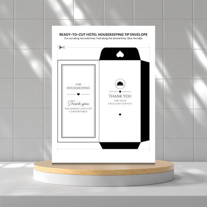 A printed housekeeping tip envelope template sheet displayed upright on a round wooden pedestal against a light gray tiled wall. The sheet shows a black-and-white envelope design with text including 'READY-TO-CUT HOTEL HOUSEKEEPING TIP ENVELOPE' and 'THANK YOU FOR YOUR EXCELLENT SERVICE.
