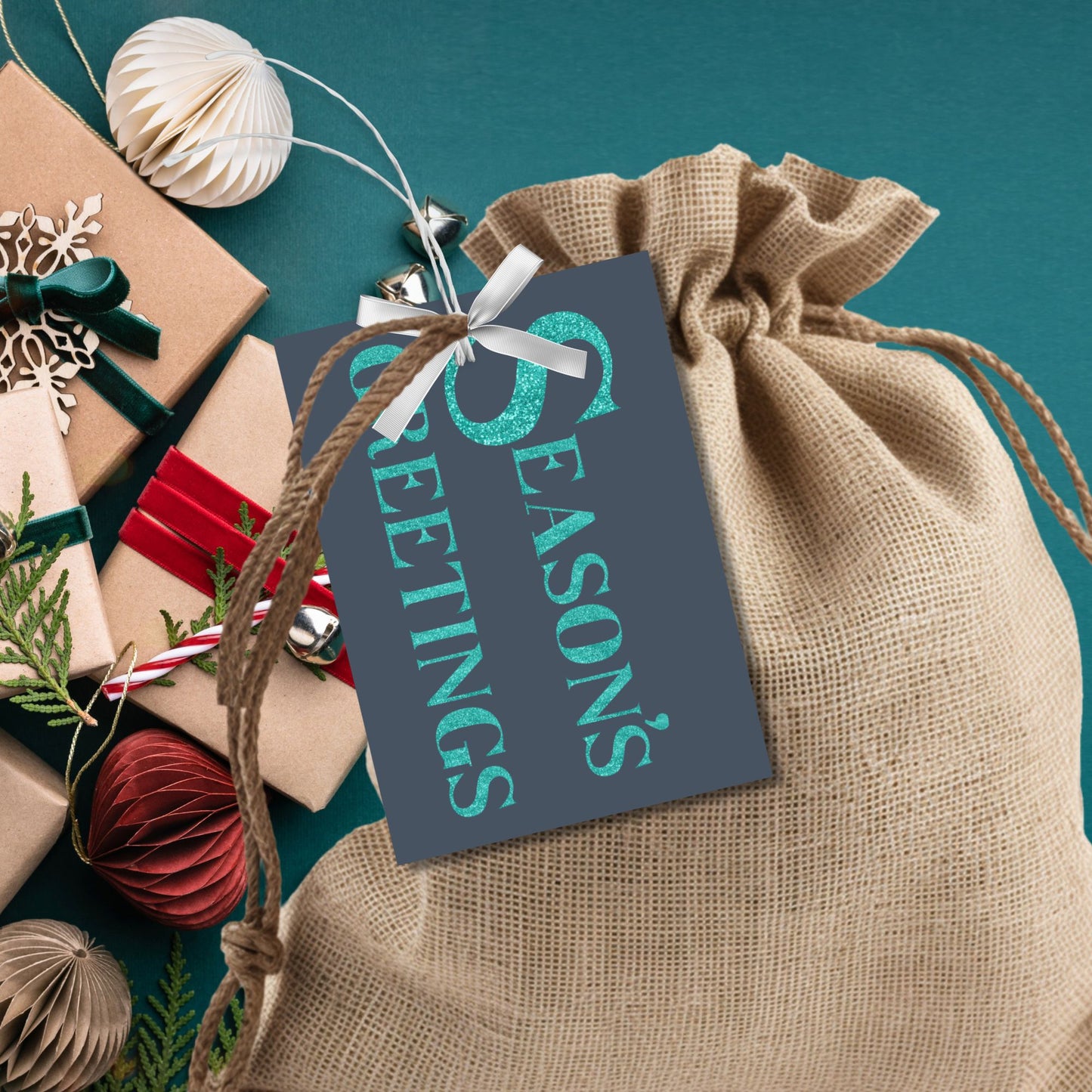 A set of ready-to-print Christmas gift tags featuring glittering turquoise text on a navy-blue background with festive messages like "Merry and Bright" and "Season's Greetings." Each tag is 2.5 x 3.5 inches, perfect for adding a vibrant touch to holiday gifting.