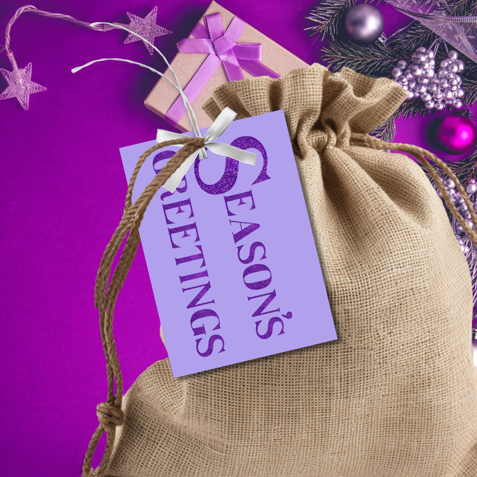 A set of ready-to-print Christmas gift tags featuring bold purple glitter text on a soft lavender background with festive messages like "Merry and Bright" and "Season's Greetings." Each tag measures 2.5 x 3.5 inches, perfect for elegant and vibrant holiday gifting.