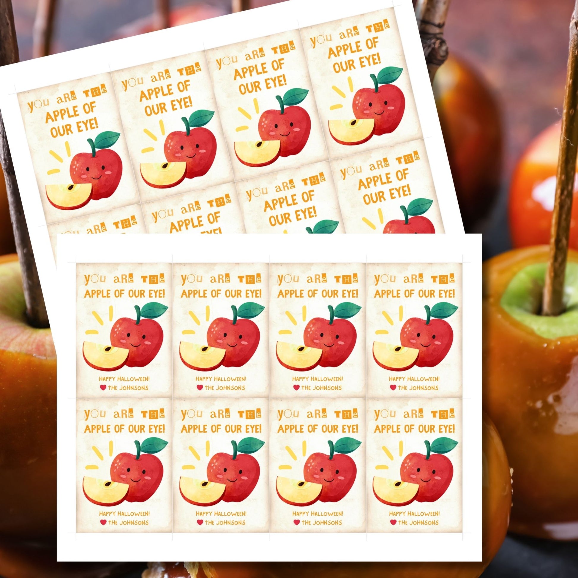 Halloween-themed printable gift tags with the message "You Are the Apple of Our Eye!" featuring a cute apple character perfect for caramel apple gifts. Tags are 2.5 x 3.5 inches, laid out 8 per sheet on a standard 8.5 x 11-inch page. Includes a printable PDF and a PDF with a link to an editable Canva template.