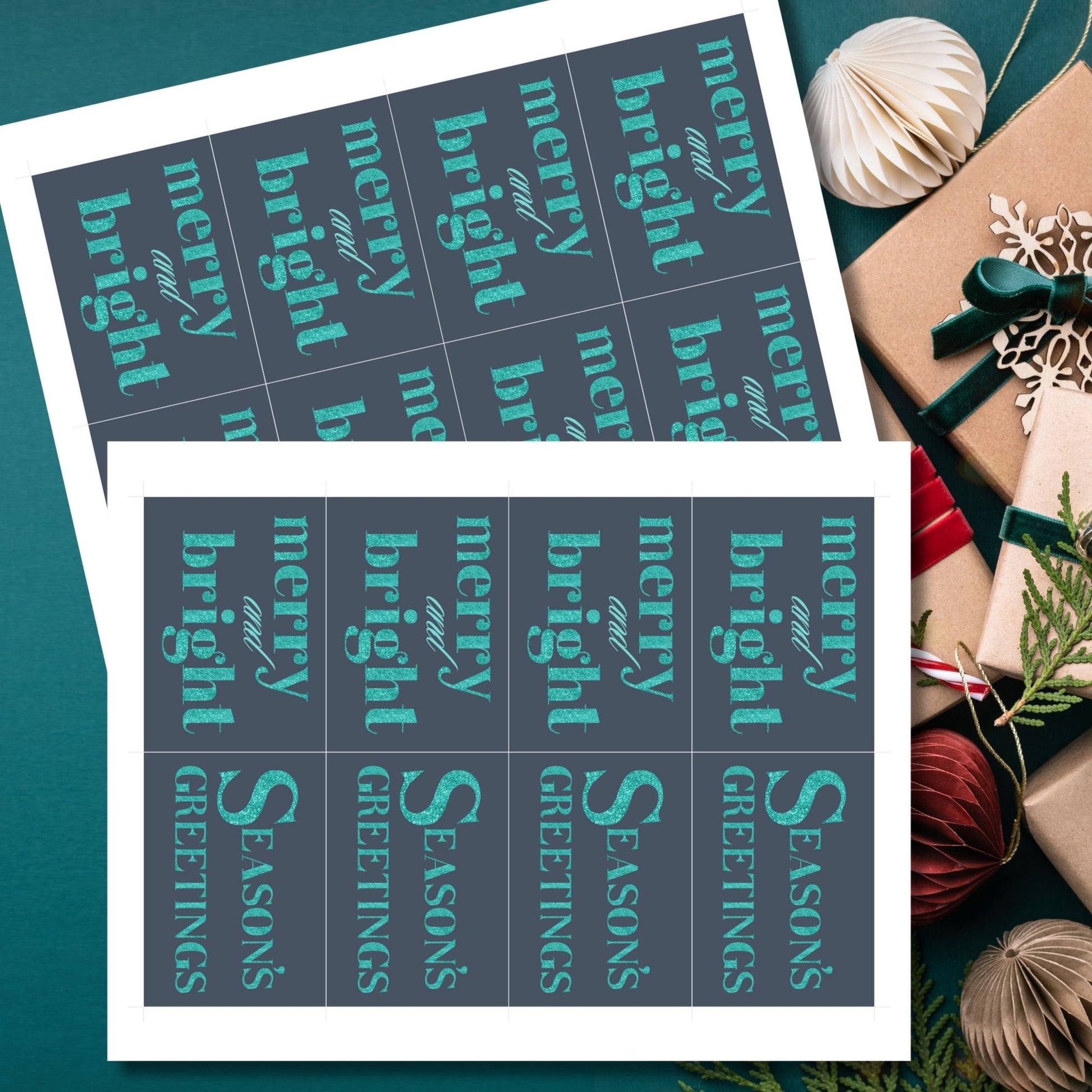 A set of ready-to-print Christmas gift tags featuring glittering turquoise text on a navy-blue background with festive messages like "Merry and Bright" and "Season's Greetings." Each tag is 2.5 x 3.5 inches, perfect for adding a vibrant touch to holiday gifting.