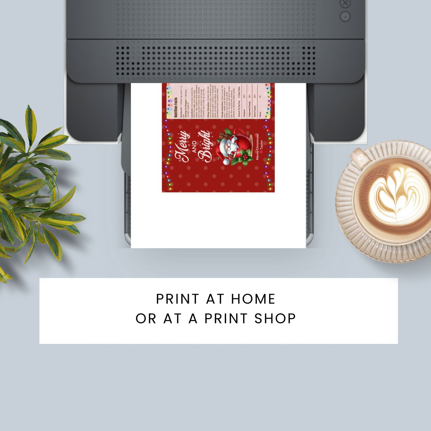Printer on a desk with a printed Christmas card, plant, and coffee cup.