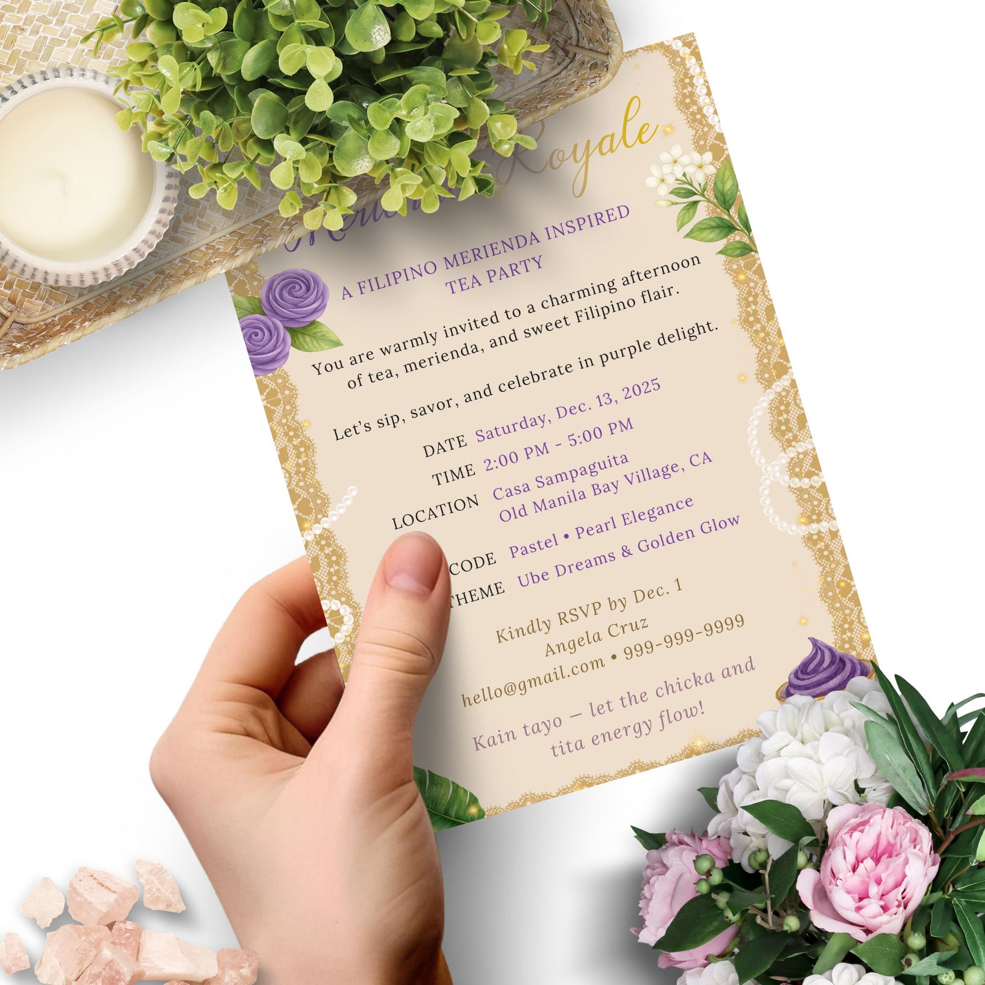 Invitation card held by a hand with floral decorations on a white background