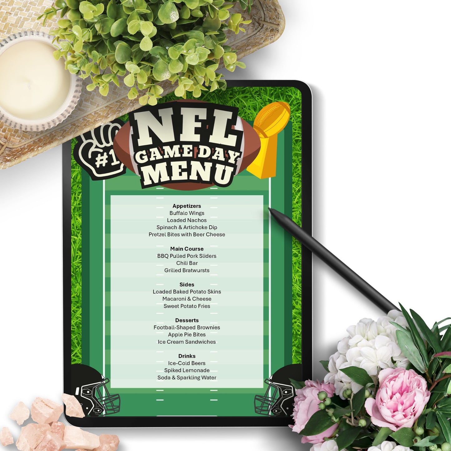 A tablet displaying an NFL Game Day Menu with a football-themed design, styled on a white surface with a pen, flowers, and greenery.