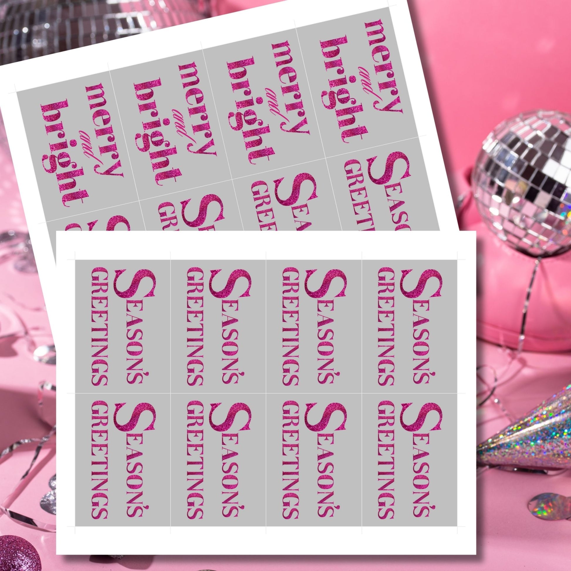 A set of ready-to-print Christmas gift tags featuring magenta glitter text on a silver-gray background with festive messages like "Merry and Bright" and "Season's Greetings." Each tag is sized at 2.5 x 3.5 inches, perfect for modern holiday gifting.