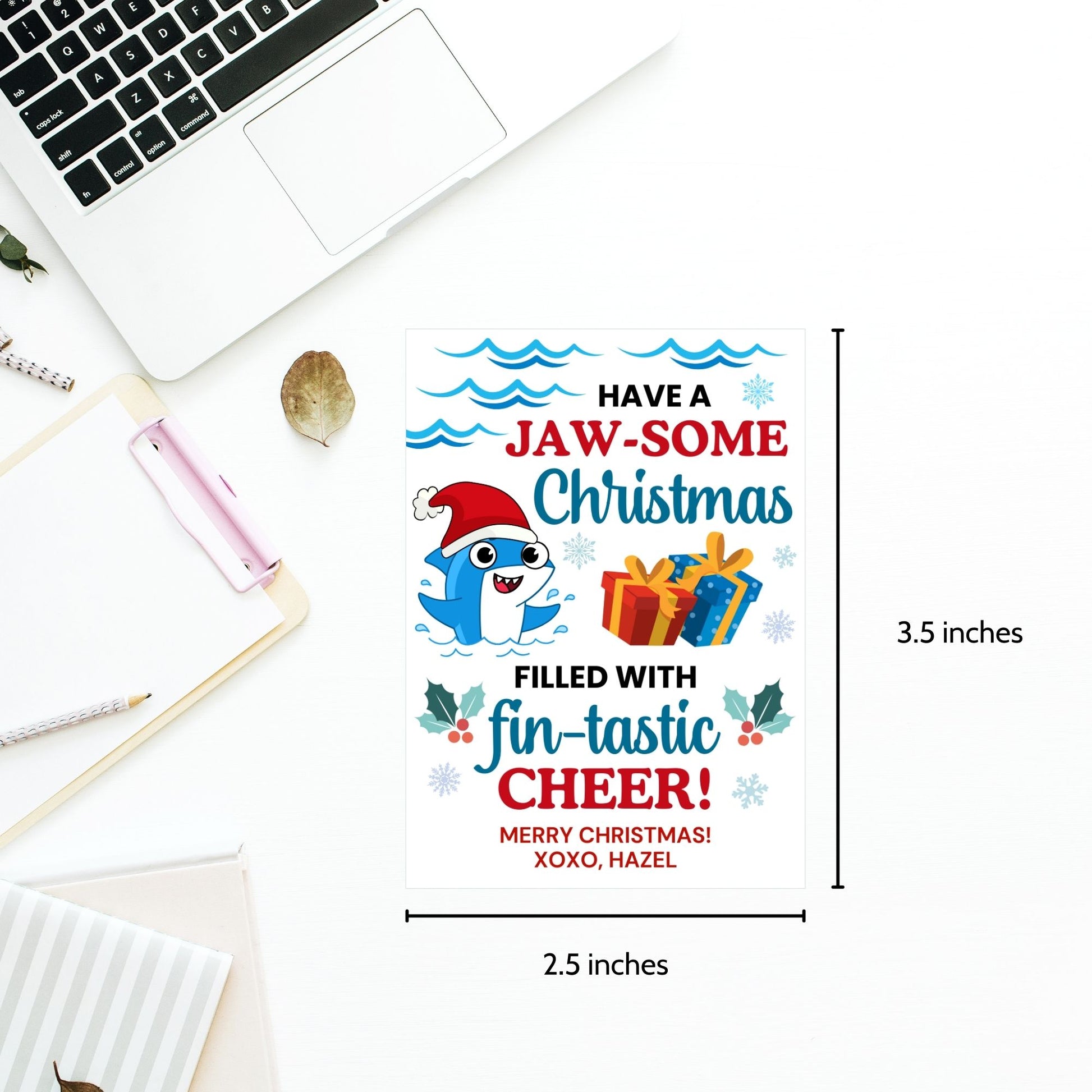 Festive shark-themed holiday gift tags featuring a smiling shark wearing a Santa hat, surrounded by waves, holly, and presents, with the message 'Have a JAW-some Christmas filled with fin-tastic cheer!' Perfect for personalized Christmas gifts.