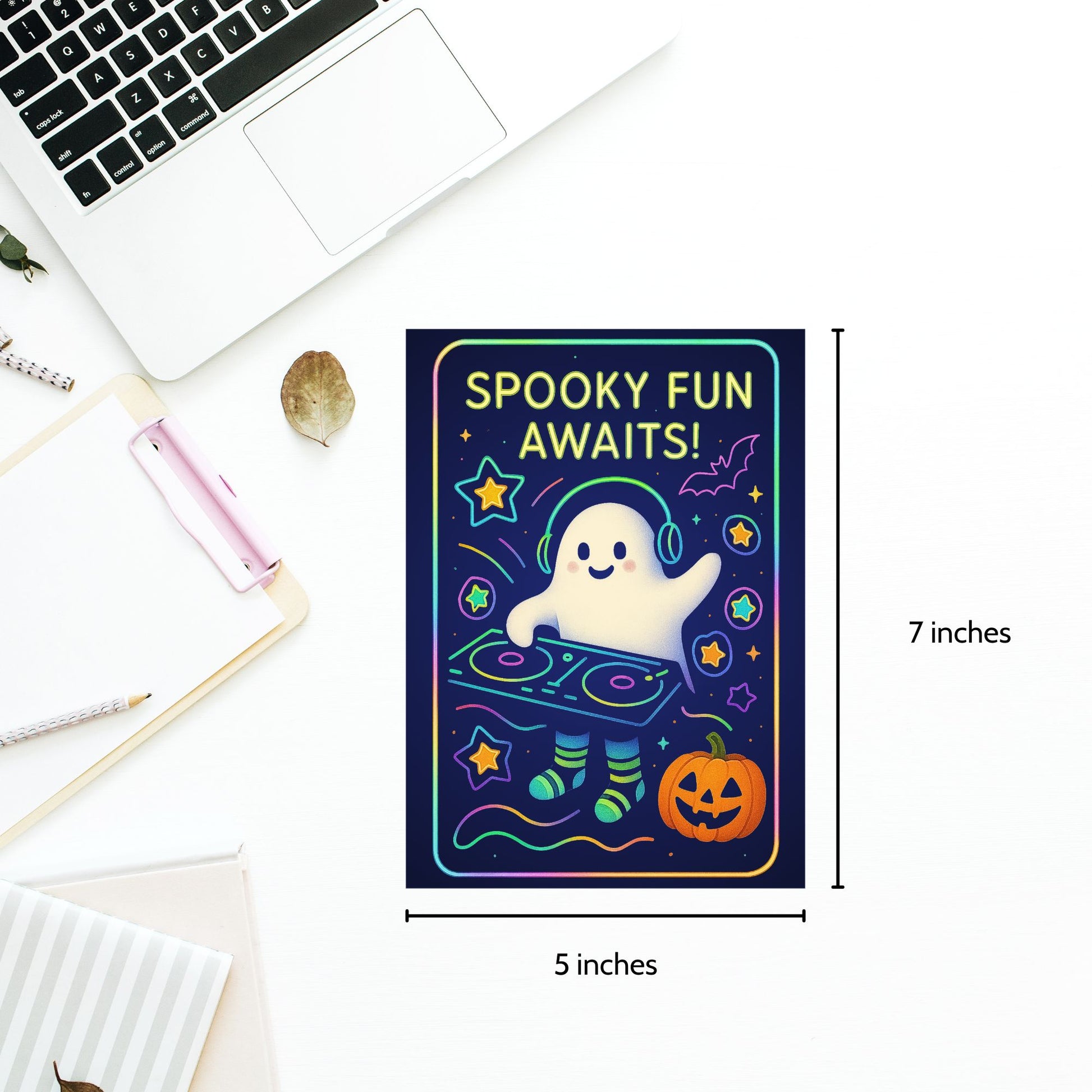 Halloween-themed card with ghost DJ illustration and 'Spooky Fun Awaits!' text, placed on a desk with laptop and stationery.