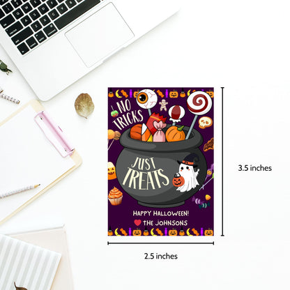  Halloween-themed printable gift tags with the message "No Tricks, Just Treats" featuring a cauldron filled with Halloween candies and treats. Tags are 2.5 x 3.5 inches, laid out 8 per sheet on a standard 8.5 x 11-inch page. Includes a printable PDF and a PDF with a link to an editable Canva template.