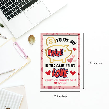 Game-themed Valentine’s Day gift tags featuring a piggy bank design with the message "You’re My Prize in This Game Called Love!" Customizable with a name for personalized gifting.