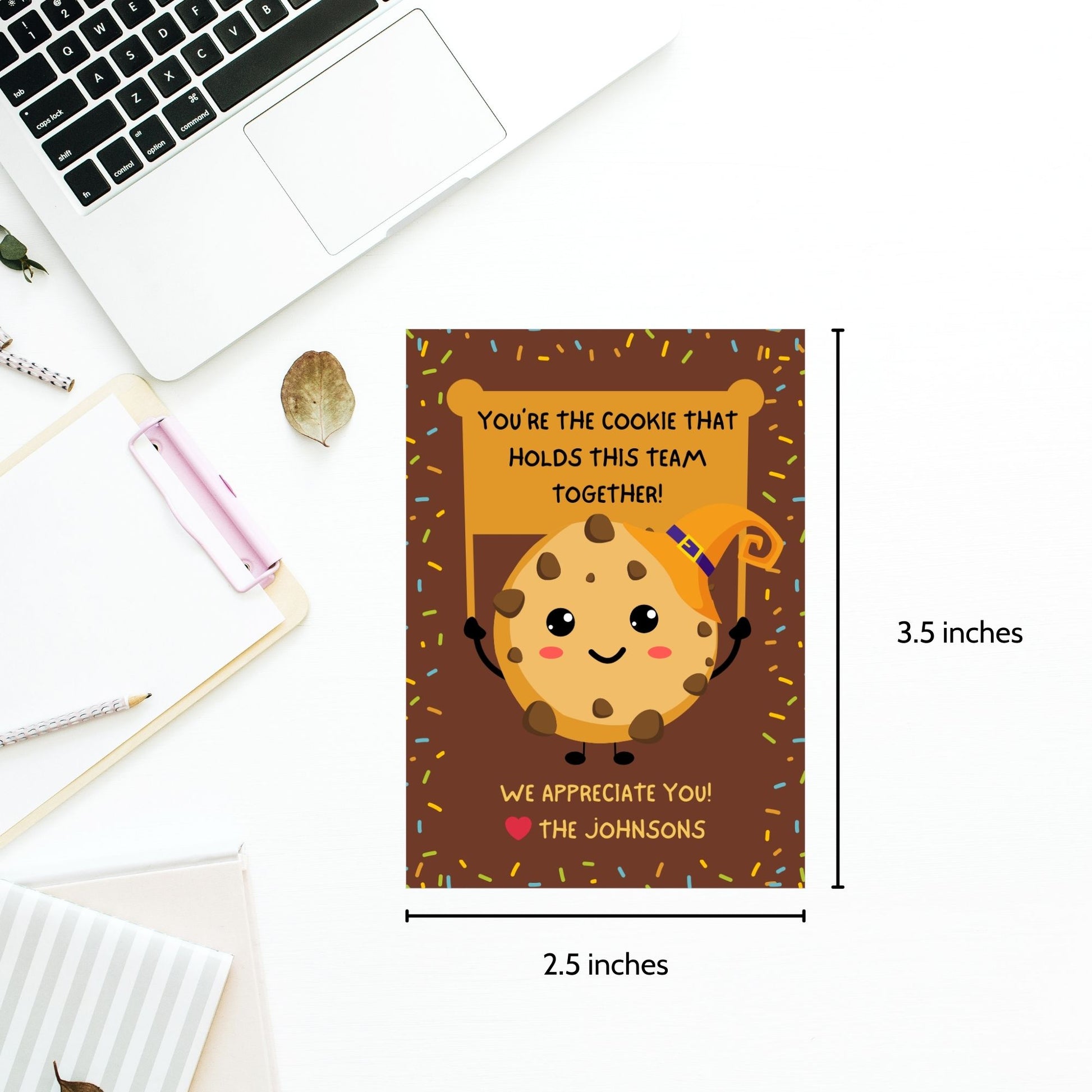 Halloween-themed printable gift tags featuring a cute cookie character in a witch's hat with a sign reading, "You're the cookie that holds this team together!" Tags are 2.5 x 3.5 inches, laid out 8 per sheet on a standard 8.5 x 11-inch page. Includes a printable PDF and a PDF with a link to an editable Canva template.