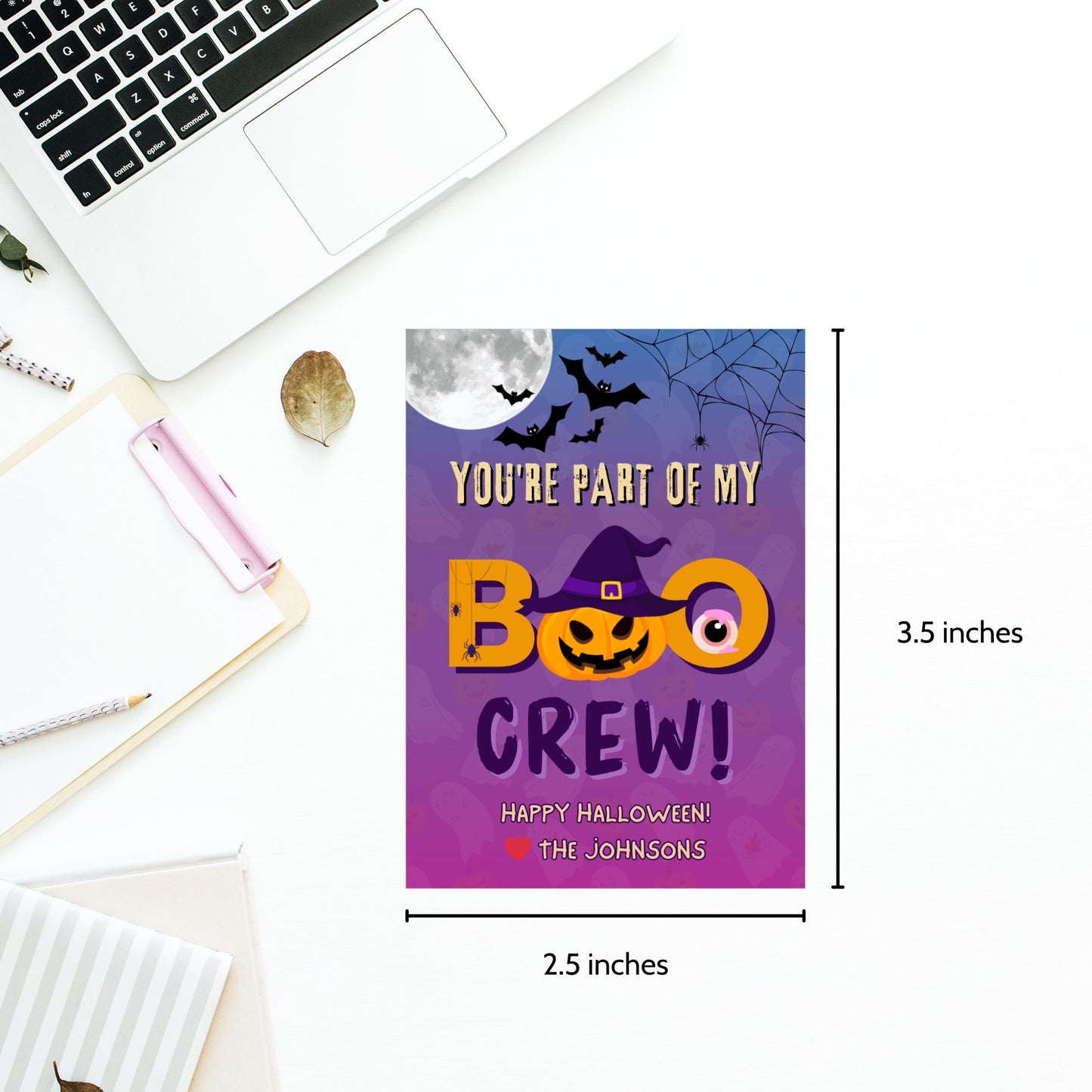 Halloween-themed card with text 'You're part of my BOO CREW!' on a white surface with a laptop.