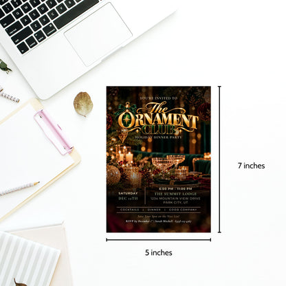 A 5x7 inch holiday dinner party invitation card for 'The Ornament Club' is shown on a white desk flat-lay with a laptop, notebook, and pen. The card features a dark festive design with gold typography and warm candlelight imagery.