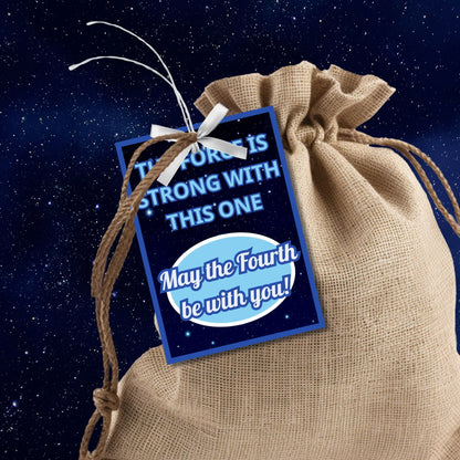 Star Wars-themed May the Fourth be with you gift tags featuring a cosmic background with stars and the text The Force is strong with this one. Perfect for Star Wars fans.